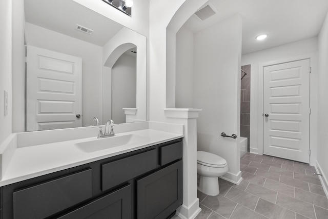 bathroom with toilet, baseboards, visible vents, and vanity