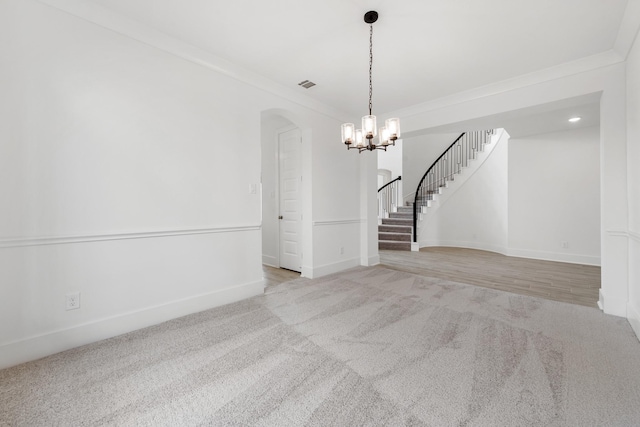 spare room featuring light carpet, visible vents, stairway, and crown molding