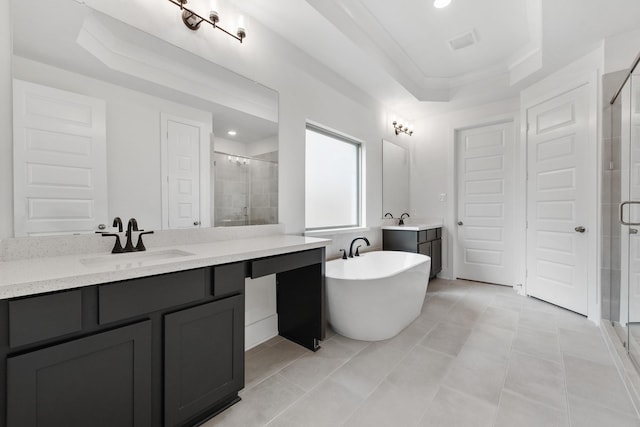 full bath with a tray ceiling, a soaking tub, visible vents, a sink, and a shower stall