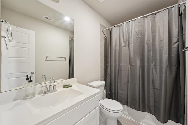 bathroom with toilet, vanity, and visible vents