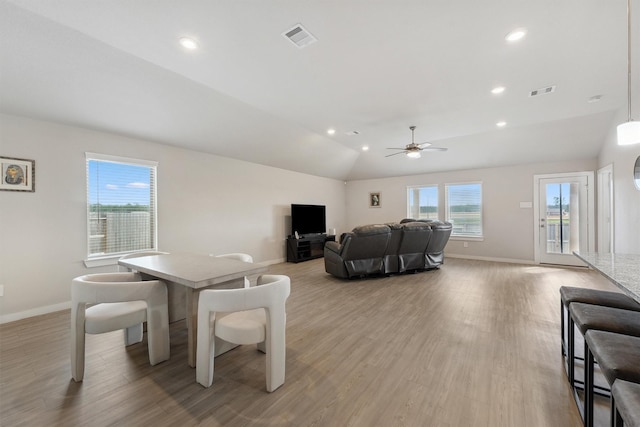 living area featuring plenty of natural light, visible vents, and vaulted ceiling