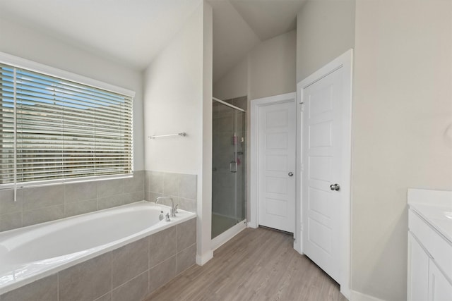 full bath featuring wood finished floors, a stall shower, vanity, and a bath