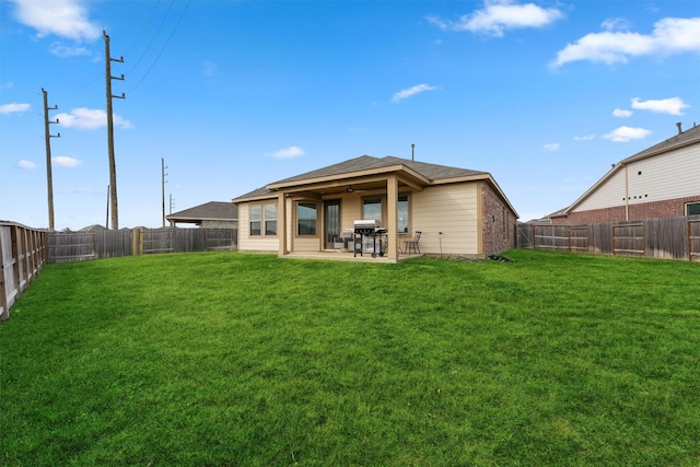 back of house with a yard, a patio area, and a fenced backyard