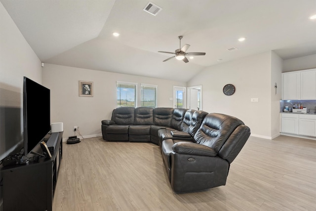 living room featuring lofted ceiling, baseboards, visible vents, and light wood-style floors