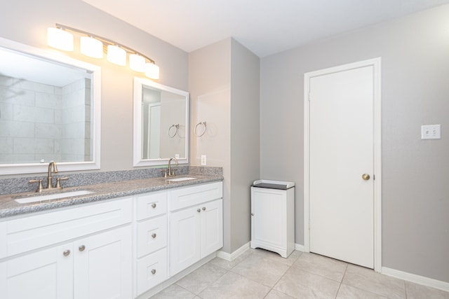 full bathroom with tile patterned flooring, a sink, baseboards, and double vanity