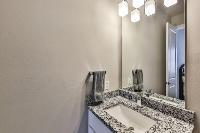 bathroom with a textured wall and vanity