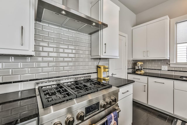 kitchen with tasteful backsplash, white cabinetry, gas range, and extractor fan