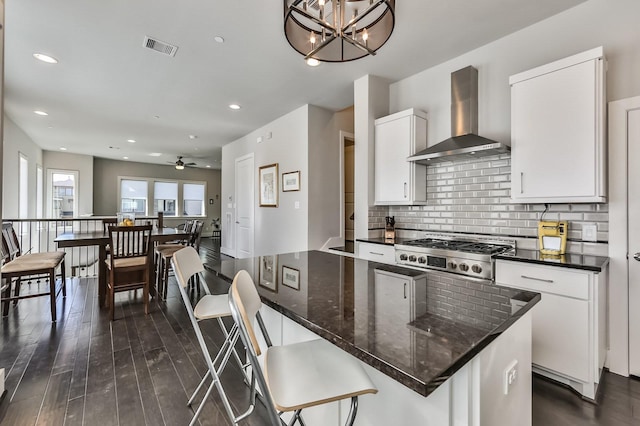 kitchen with stainless steel gas cooktop, visible vents, backsplash, wall chimney exhaust hood, and dark wood finished floors