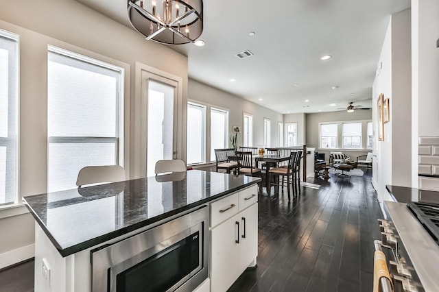 kitchen with a chandelier, recessed lighting, dark wood-style flooring, white cabinets, and stainless steel microwave