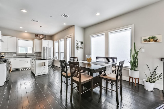 dining area featuring dark wood finished floors, visible vents, and recessed lighting