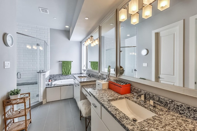 bathroom featuring two vanities, a stall shower, a sink, tile patterned flooring, and a bath