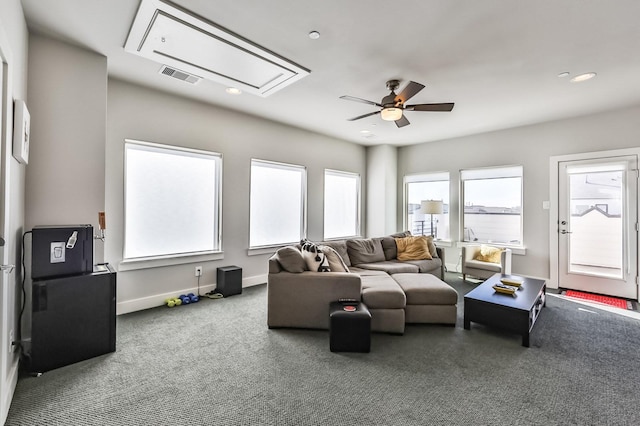 living area with attic access, visible vents, baseboards, a ceiling fan, and carpet