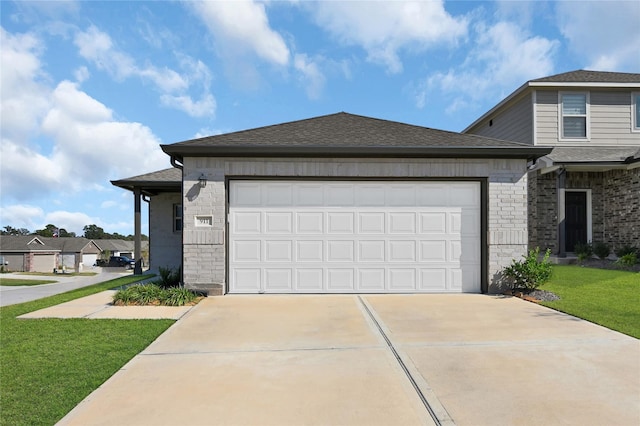 view of front of home with an attached garage, driveway, a front yard, and roof with shingles