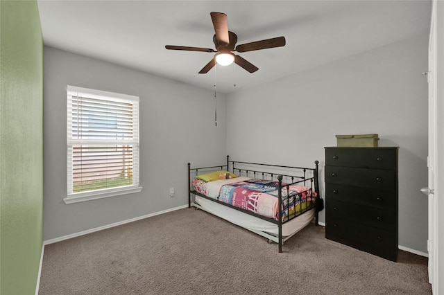 carpeted bedroom with ceiling fan and baseboards