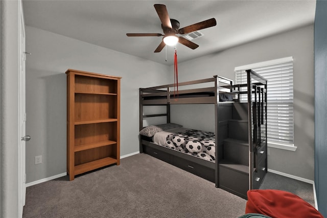 carpeted bedroom featuring visible vents, multiple windows, baseboards, and a ceiling fan