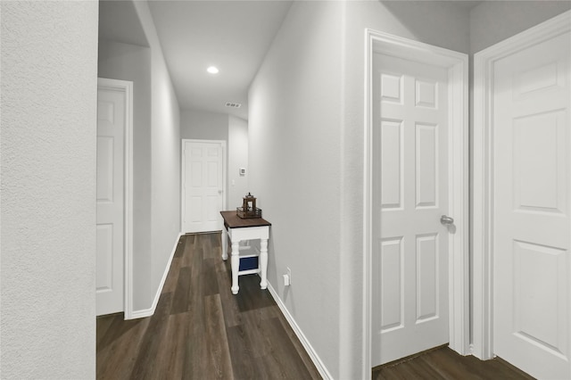 corridor featuring recessed lighting, dark wood-style flooring, visible vents, and baseboards