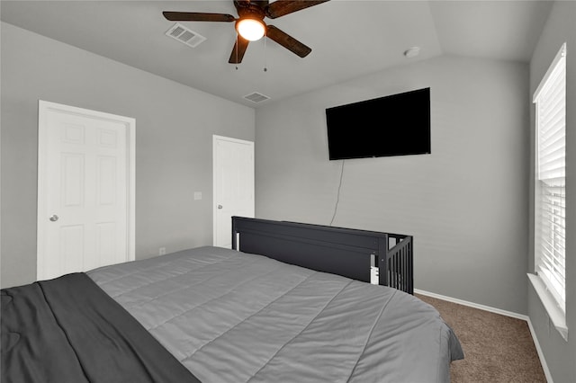 carpeted bedroom with lofted ceiling, baseboards, visible vents, and a ceiling fan