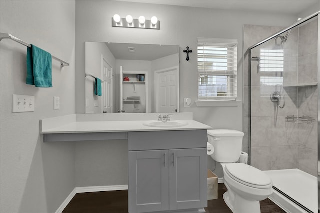 bathroom with toilet, a shower stall, and baseboards