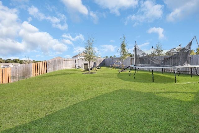 view of yard featuring a fenced backyard and a trampoline