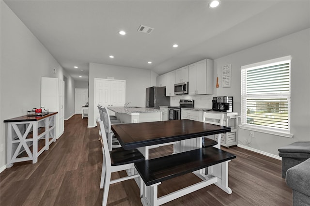 dining room with dark wood-style flooring, visible vents, and recessed lighting