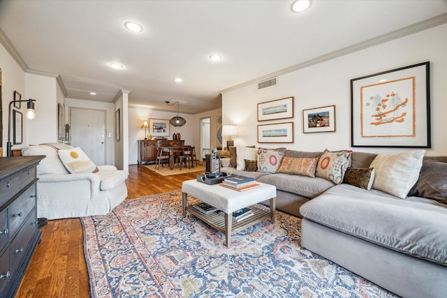 living area featuring ornamental molding, wood finished floors, and visible vents