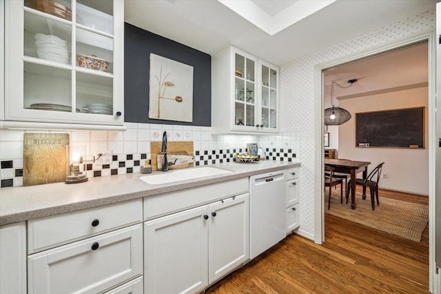 bar with dishwasher, wood finished floors, a sink, and wallpapered walls