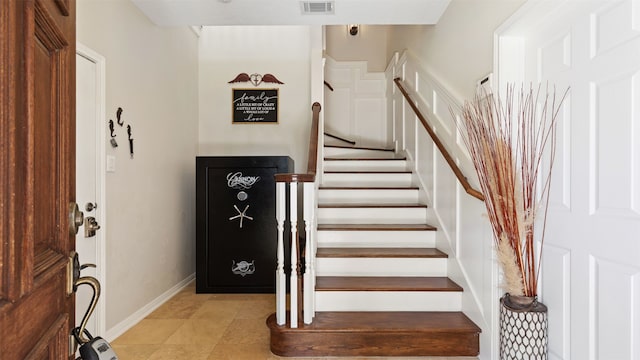 stairway with baseboards and visible vents