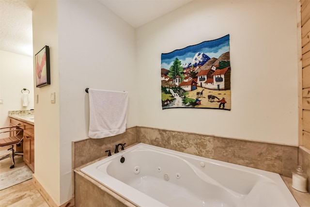 bathroom with vanity and a tub with jets