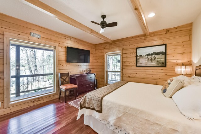 bedroom with wood walls, a ceiling fan, dark wood-style flooring, and beam ceiling