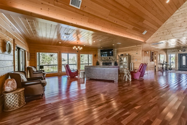 living area with wooden ceiling, a notable chandelier, a fireplace, wood finished floors, and visible vents