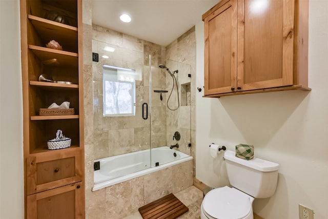 bathroom with toilet, built in shelves, and tiled shower / bath