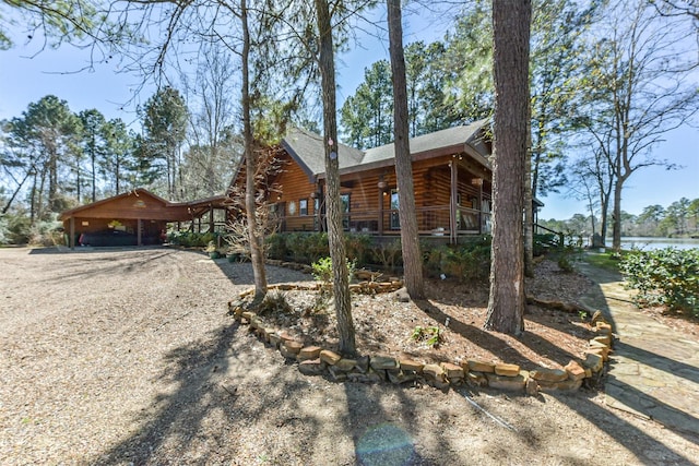 view of front of property featuring a water view, driveway, and log siding