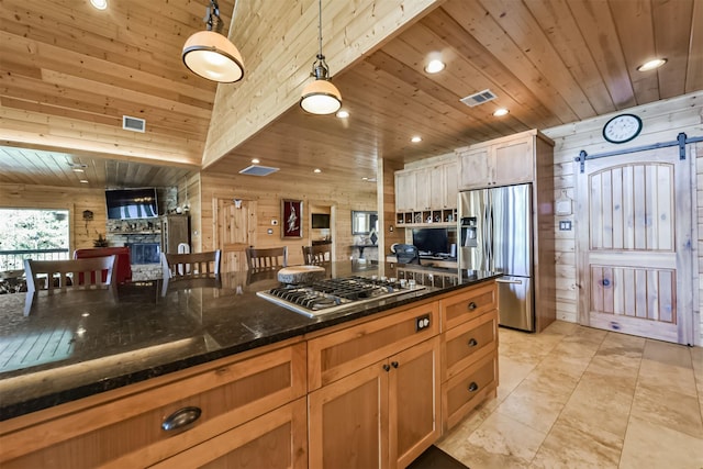 kitchen featuring a barn door, wooden ceiling, wooden walls, stainless steel appliances, and visible vents