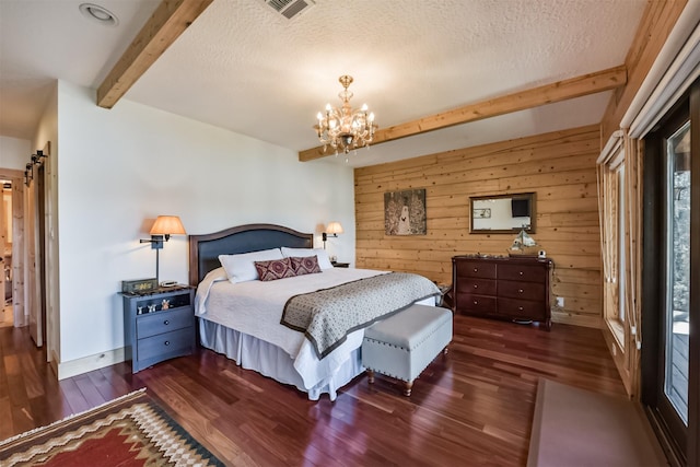 bedroom with beam ceiling, visible vents, wooden walls, and wood finished floors