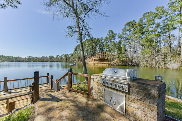 view of dock featuring a water view and an outdoor kitchen