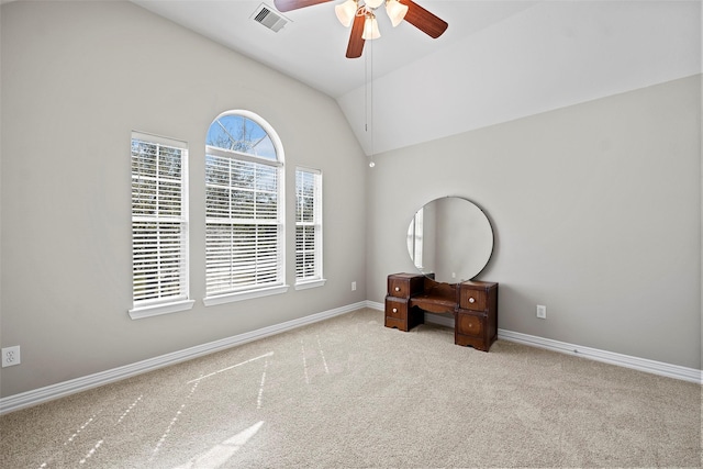 interior space with carpet, visible vents, vaulted ceiling, ceiling fan, and baseboards