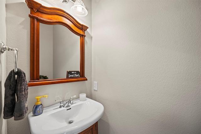 bathroom featuring a textured wall and a sink