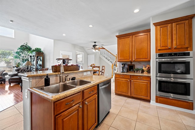 kitchen featuring an island with sink, plenty of natural light, appliances with stainless steel finishes, and a sink