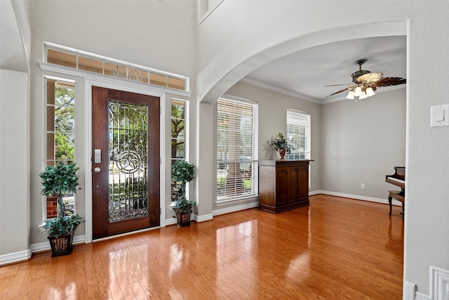 entryway featuring crown molding, wood-type flooring, a ceiling fan, and a healthy amount of sunlight