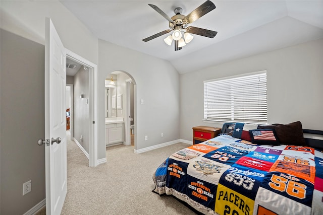 bedroom with arched walkways, ceiling fan, light colored carpet, baseboards, and vaulted ceiling