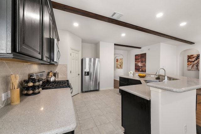 kitchen with tasteful backsplash, visible vents, beam ceiling, appliances with stainless steel finishes, and a sink