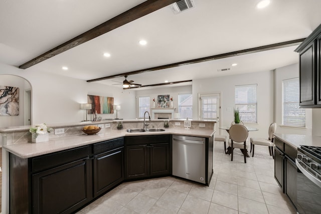 kitchen with visible vents, light countertops, beam ceiling, stainless steel appliances, and a sink