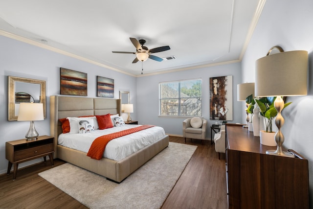 bedroom featuring a ceiling fan, crown molding, wood finished floors, and visible vents