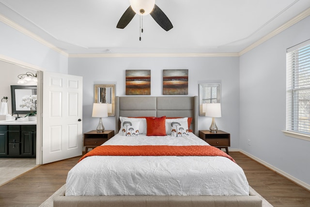 bedroom featuring crown molding, wood finished floors, baseboards, and a sink