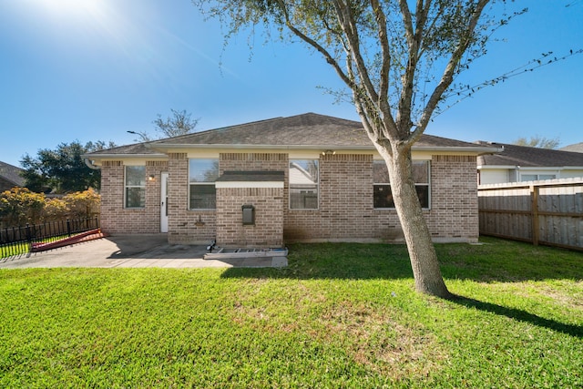 back of property featuring a patio area, a fenced backyard, brick siding, and a yard