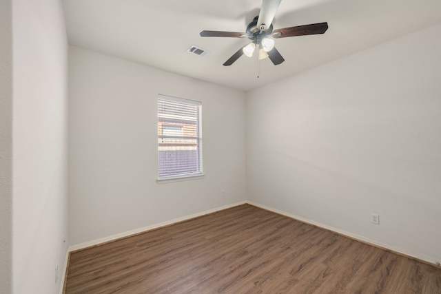 spare room with ceiling fan, wood finished floors, visible vents, and baseboards