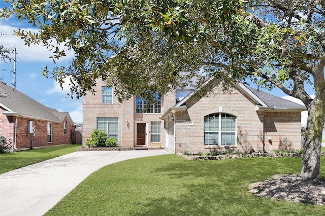 view of front of house with a front yard and brick siding