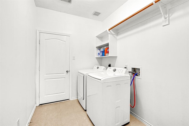 clothes washing area featuring laundry area, baseboards, washer and clothes dryer, and light tile patterned flooring