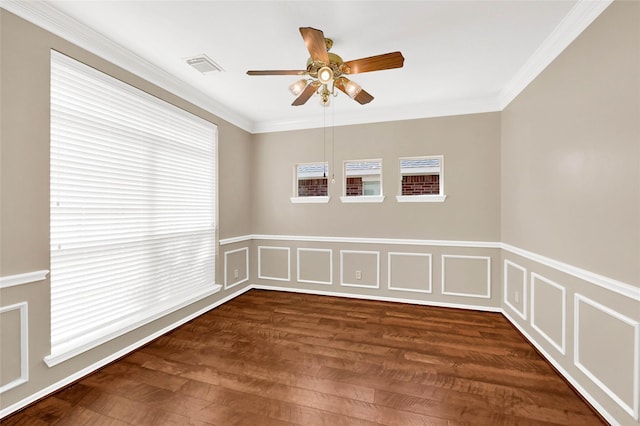 unfurnished room with dark wood-style floors, visible vents, a decorative wall, and crown molding