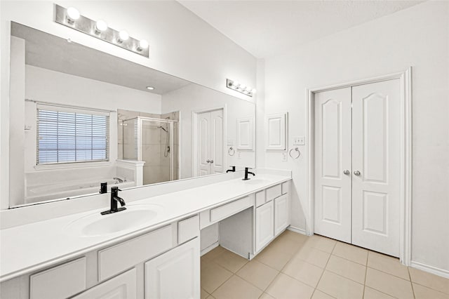 bathroom with double vanity, tile patterned floors, a sink, and a shower stall